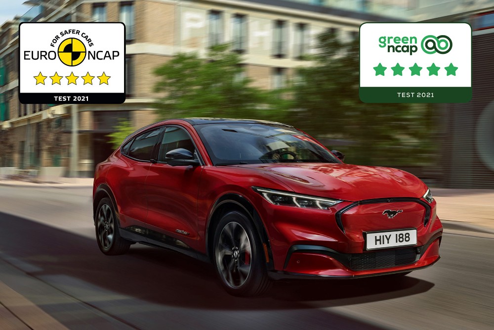 Piros Mustang Mach-E halad az úton, a képre az NCAP biztonsági díj logói vannak ráhelyezve.