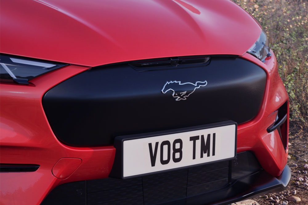 Közelkép egy Race Red színű Mustang Mach-E GT Rally első lökhárítójáról.