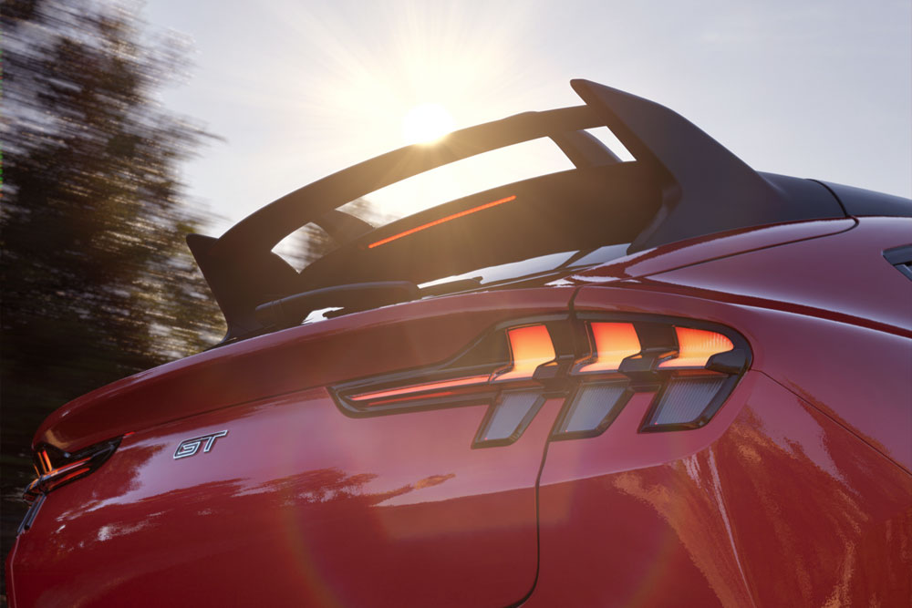 Közelkép egy Race Red színű Mustang Mach-E GT Rally hátsó spoileréről.