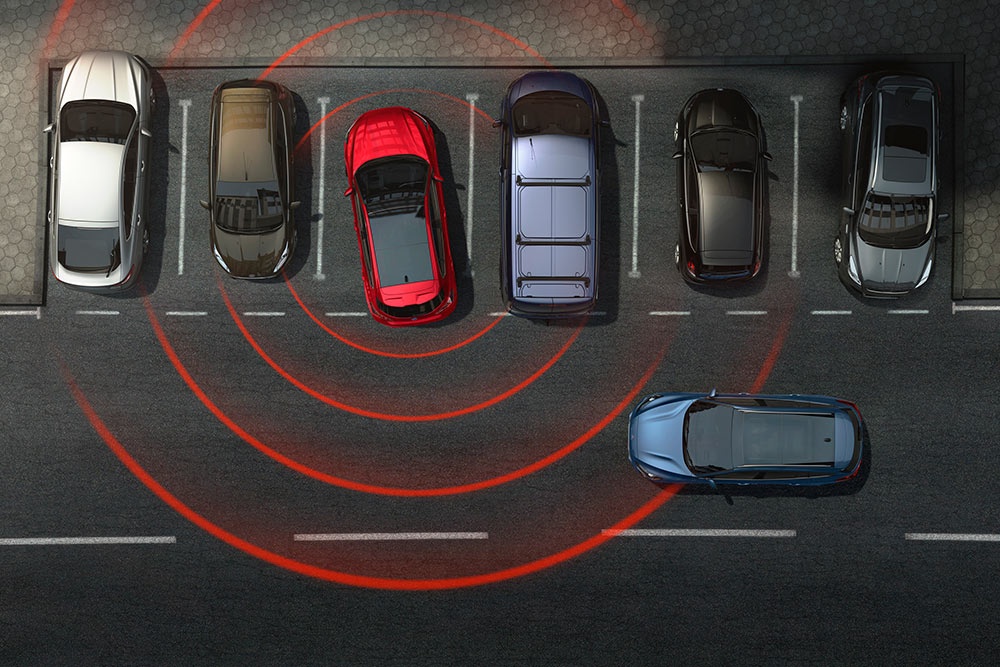 Grafika, amely egy Ford autót mutat, amint kiáll egy parkolóhelyről, aktív keresztirányú forgalomra figyelmeztető rendszerrel