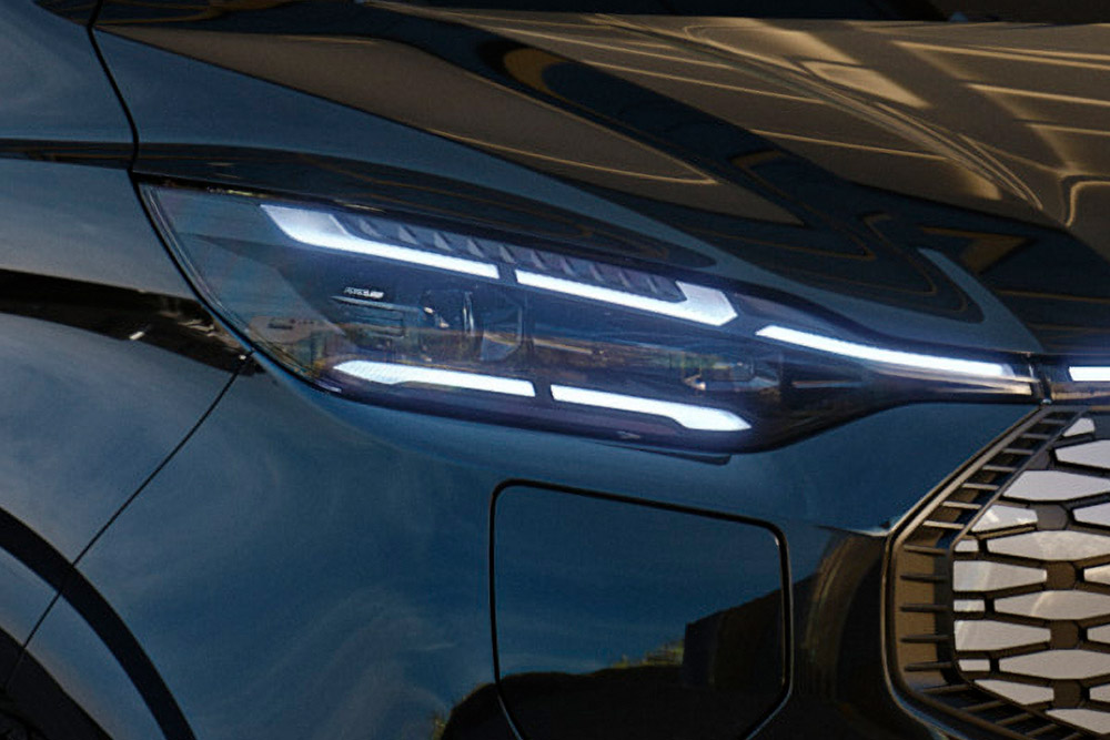 Közelkép a Ford Tourneo Custom LED-fényszórójáról, bekapcsolt állapotban.