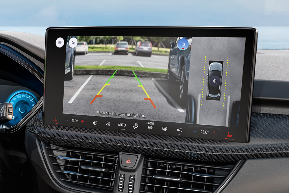 Egy Ford Kuga utasterének közelképe, fókuszban a műszerfalon látható 360°-os kamera képével.