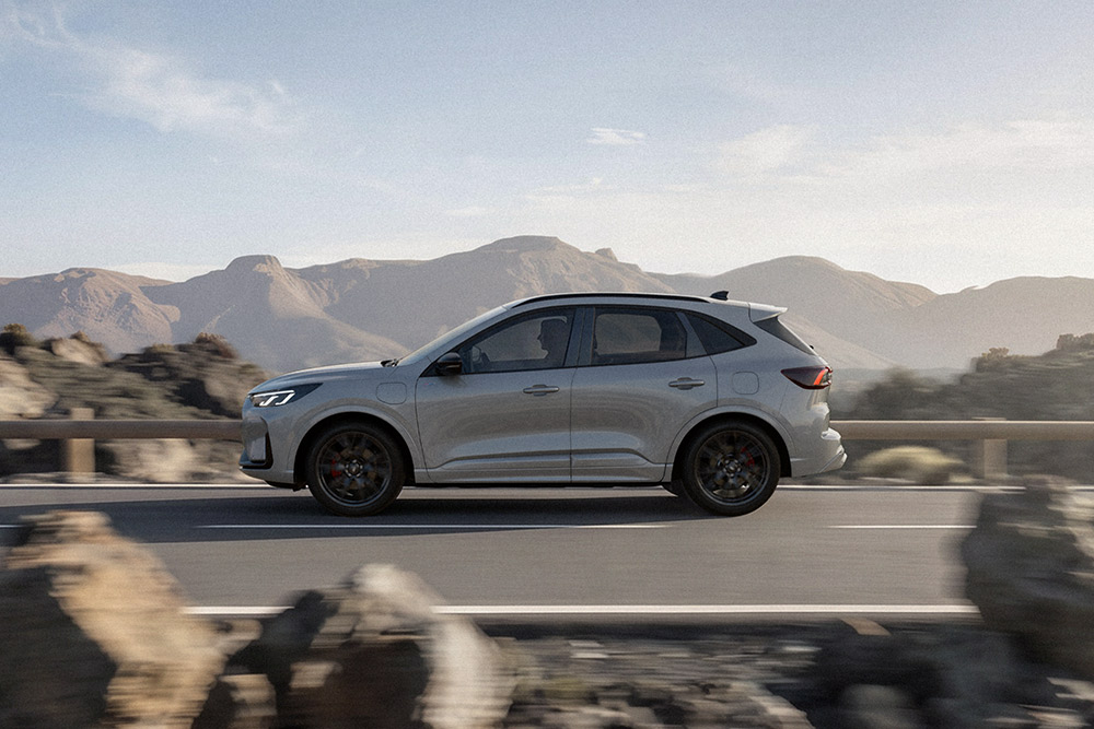 Ezüstszínű Ford Kuga egy festői hegyi úton halad.
