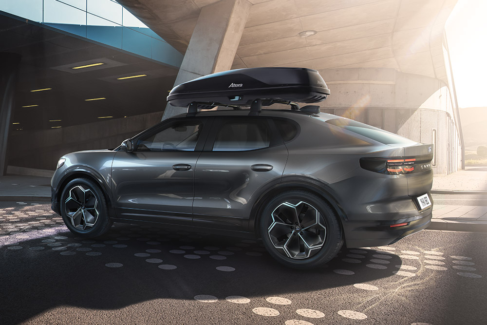 Ezüstszínű Ford Capri parkol egy modern luxusépület előtt.