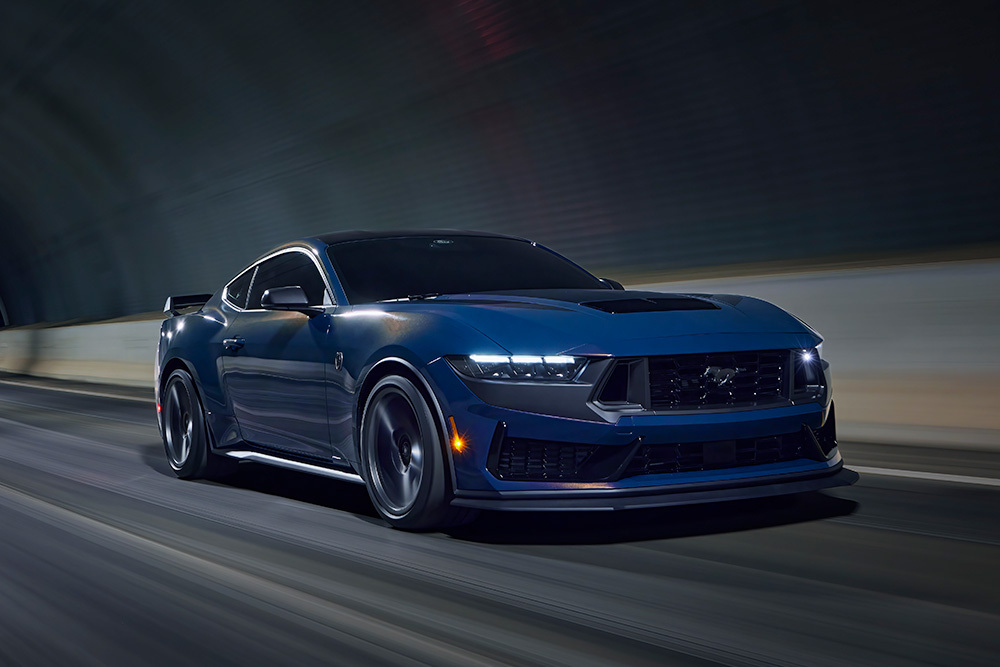 Egy világos szürkéskék Ford Mustang sportkocsi halad át egy alagúton.