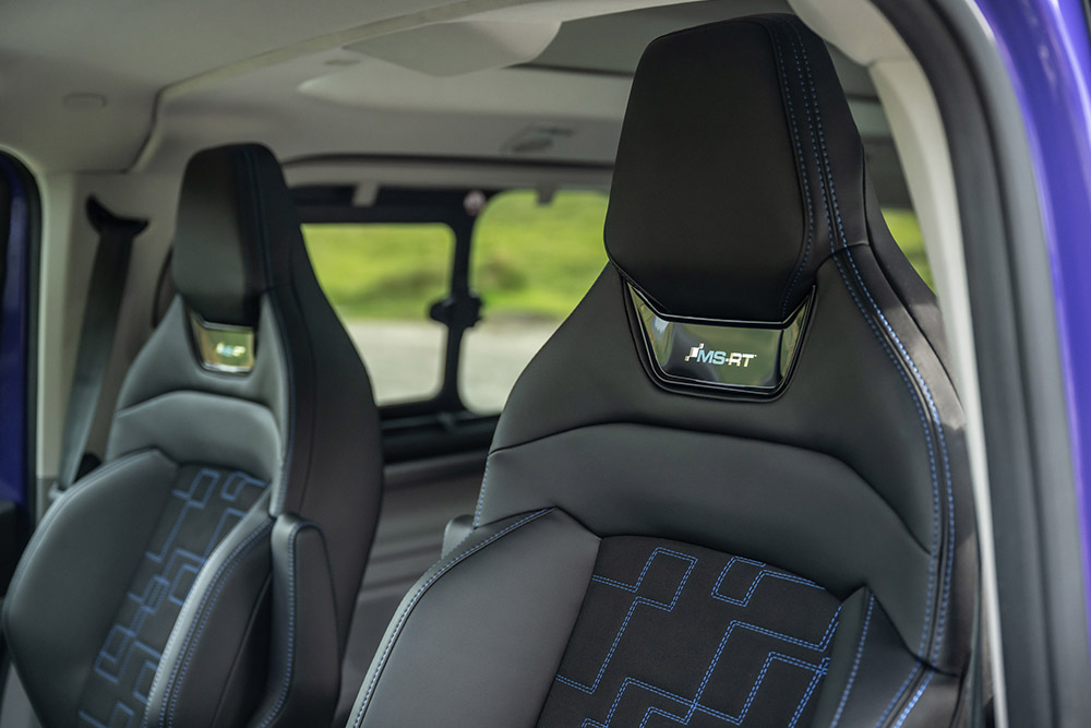A Ford Tourneo Custom MS-RT modellben a fekete bőr és velúr első üléseket látjuk kék kontrasztos varrással és MS-RT logóval.
