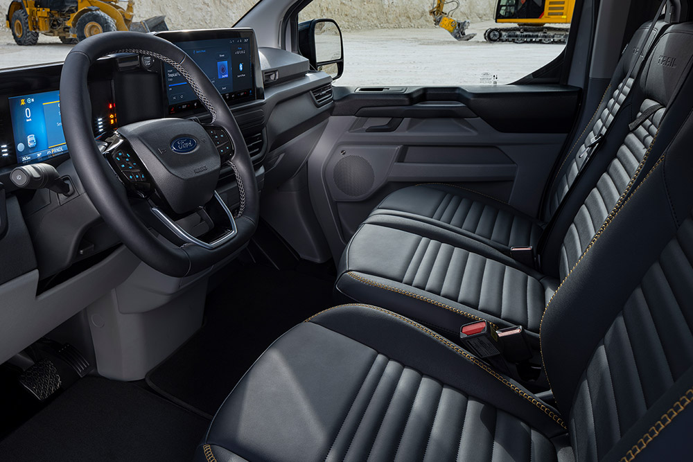 Egy Ford E-Transit Custom Sport elektromos személyszállító belseje fekete és aranyszínű ülésekkel.