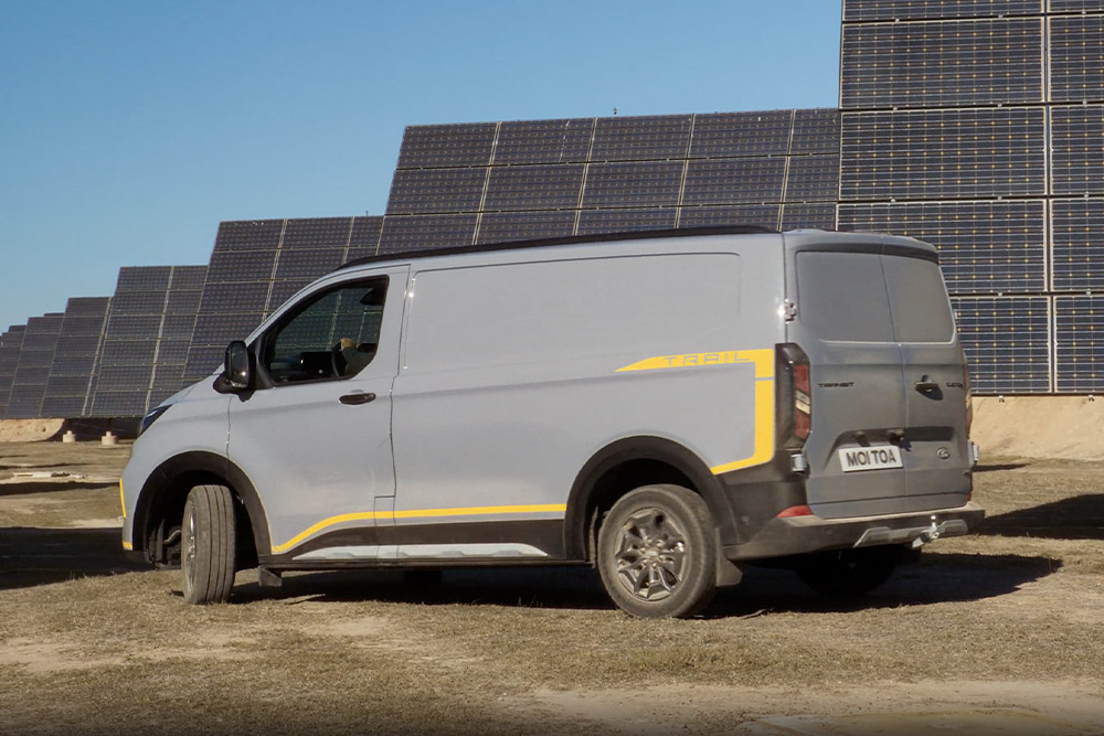 Egy szürke Ford Transit Custom Trail sárga dekorcsíkokkal.