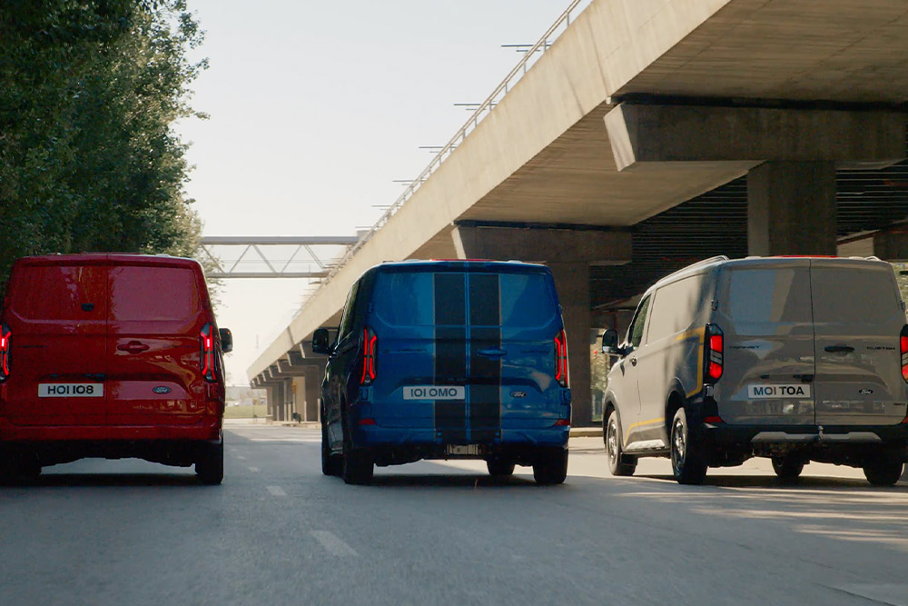 Három Ford Transit Custom áruszállító egy autópályán.