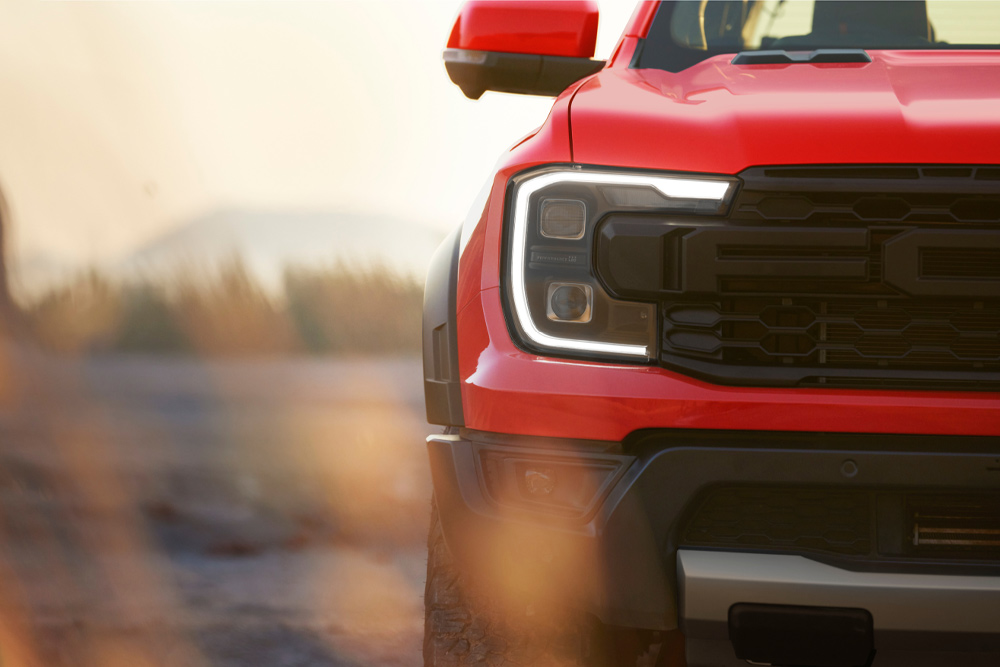 Közelképen látjuk egy piros Ford Ranger Raptor első hűtőrácsát.