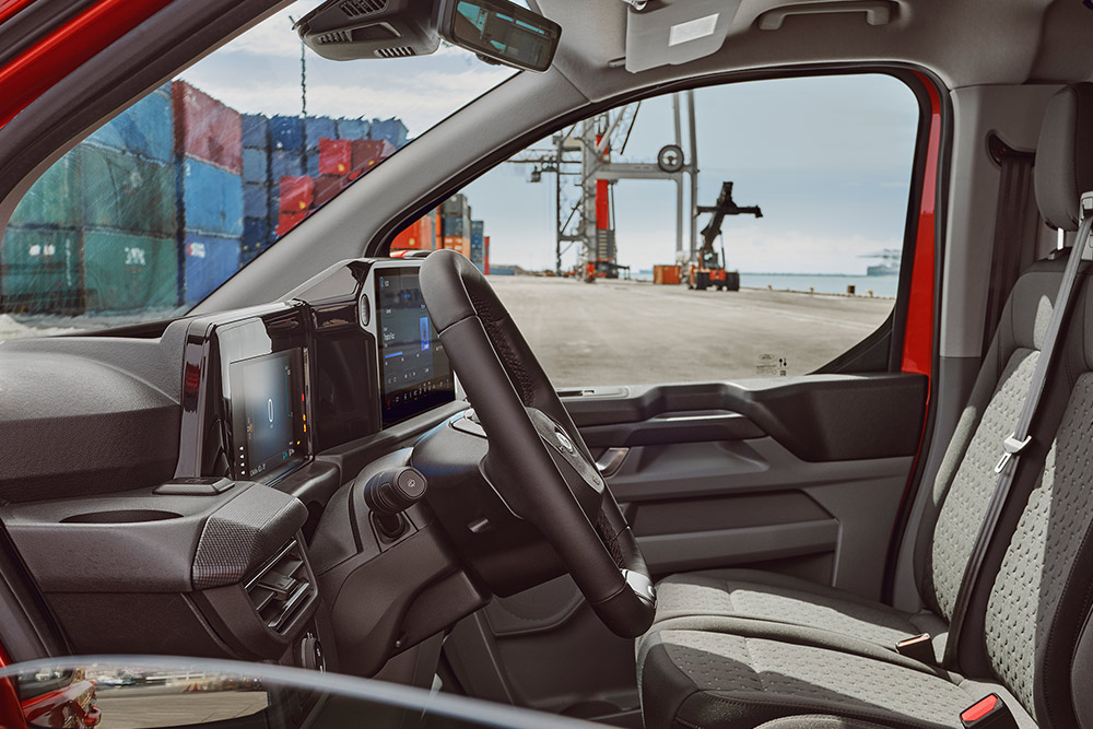 Egy Ford E-Transit Custom elektromos áruszállító belső tere vezető- és utasülésekkel.