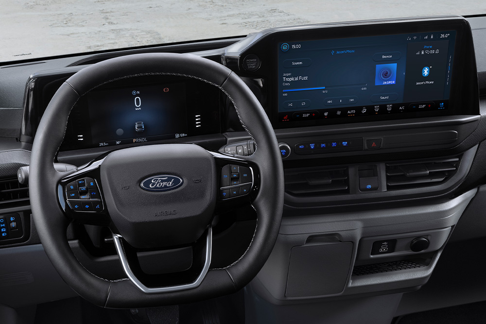 Egy Ford E-Transit Custom elektromos áruszállító belső tere vezető- és utasülésekkel.