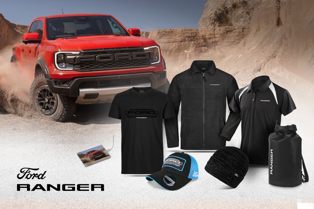 Ford Ranger kollekció fekete pólóval, dzsekivel, sapkával és wetpackkel, valamint egy piros Rangerrel a háttérben.