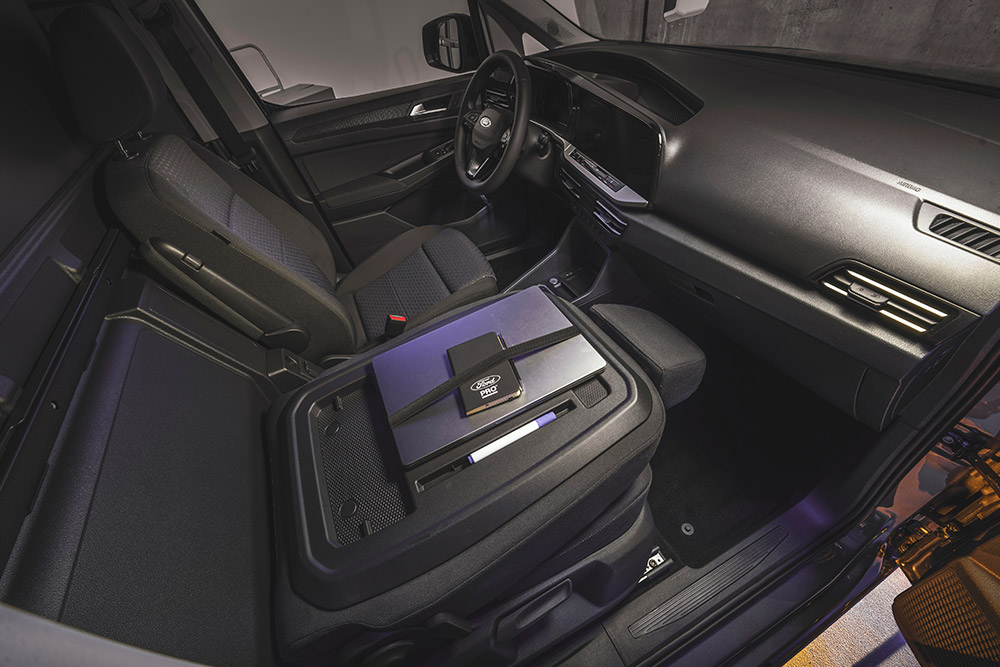A Ford Transit Connect utasterében a műszerfalat, az üléseket, valamint a középkonzolra helyezett laptopot és telefont látjuk.