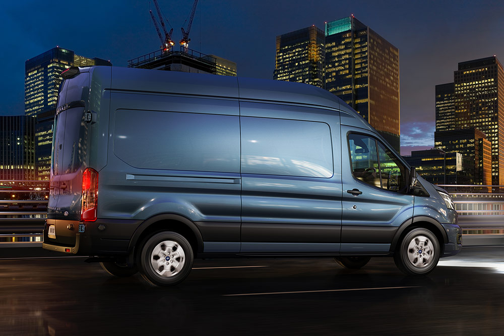 Kék Ford Transit éjszaka a város utcáin közlekedik. 