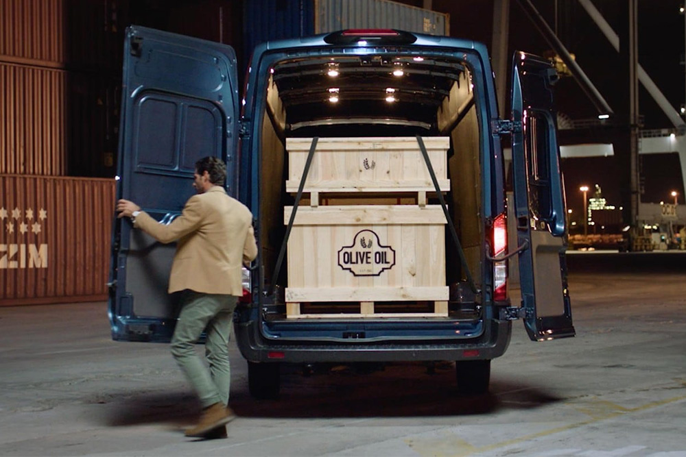 Egy Ford Transit Van nyitott hátsó ajtókkal és benne elhelyezett rakománnyal.